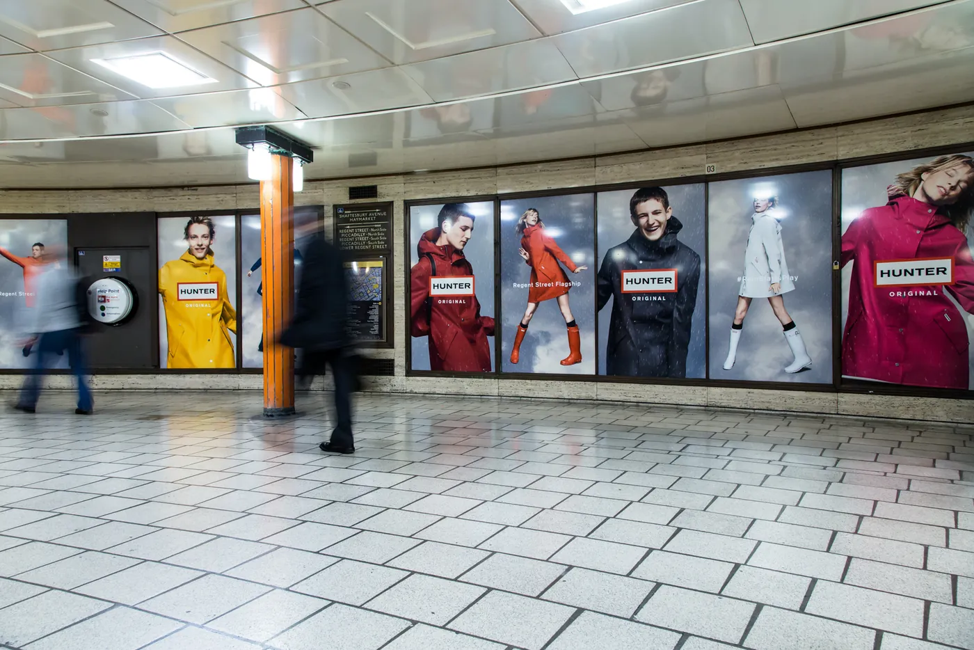 Hunter Rain Starts Play posters lining a concourse at Piccadilly Circus station