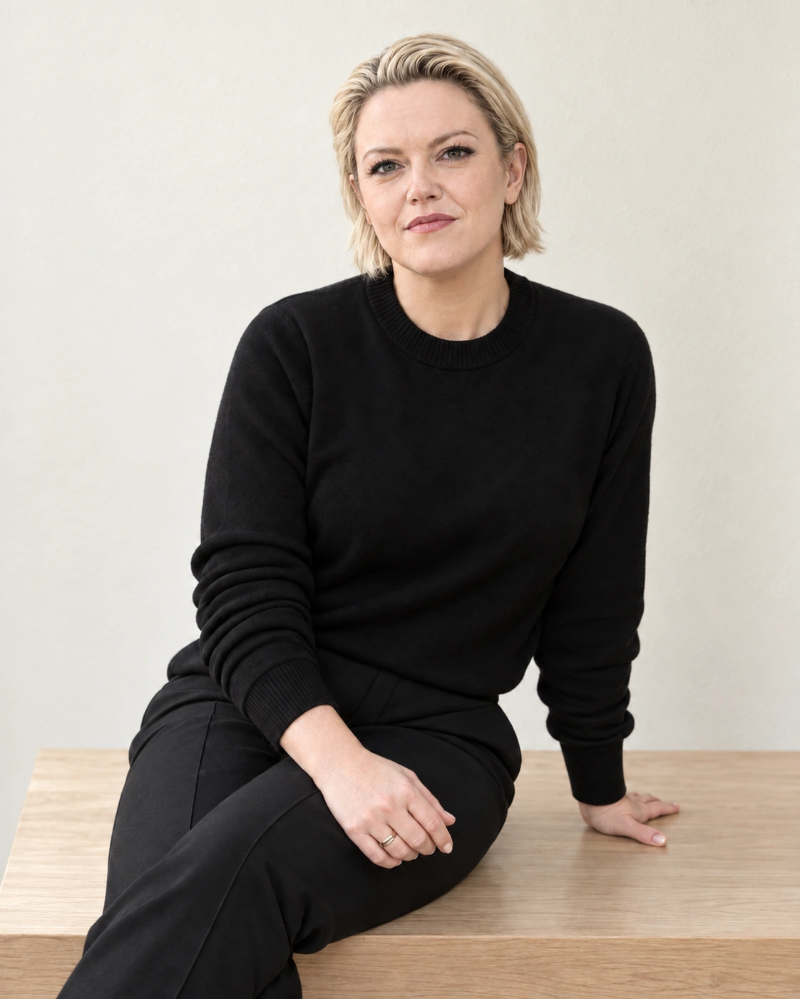 Michelle Sadlier seated on a wooden bench in a black top