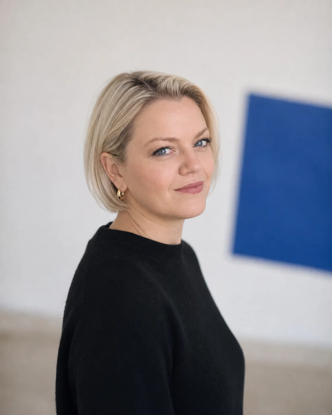 Michelle Sadlier in a minimal white space with a blue artwork